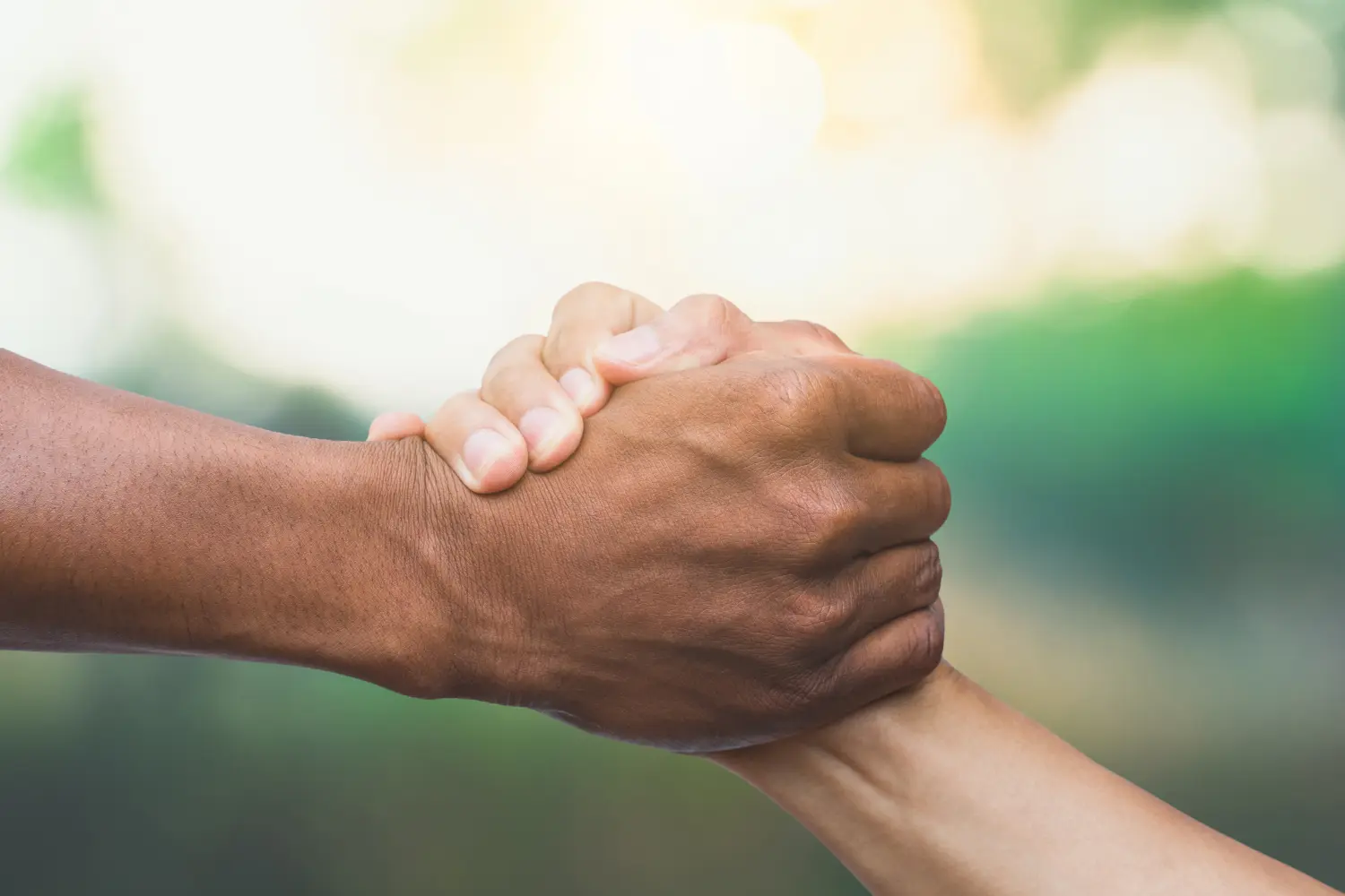 Konzept „Helfen, Retten, Freundschaft“. Handgesten helfen vor natürlichem Hintergrund und bei Sonnenlicht.